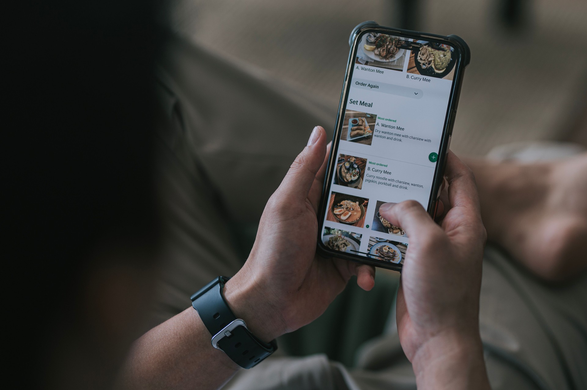 High angle view Close up Asian woman using meal delivery service ordering food online with mobile app on smartphone in the living room at a cozy home