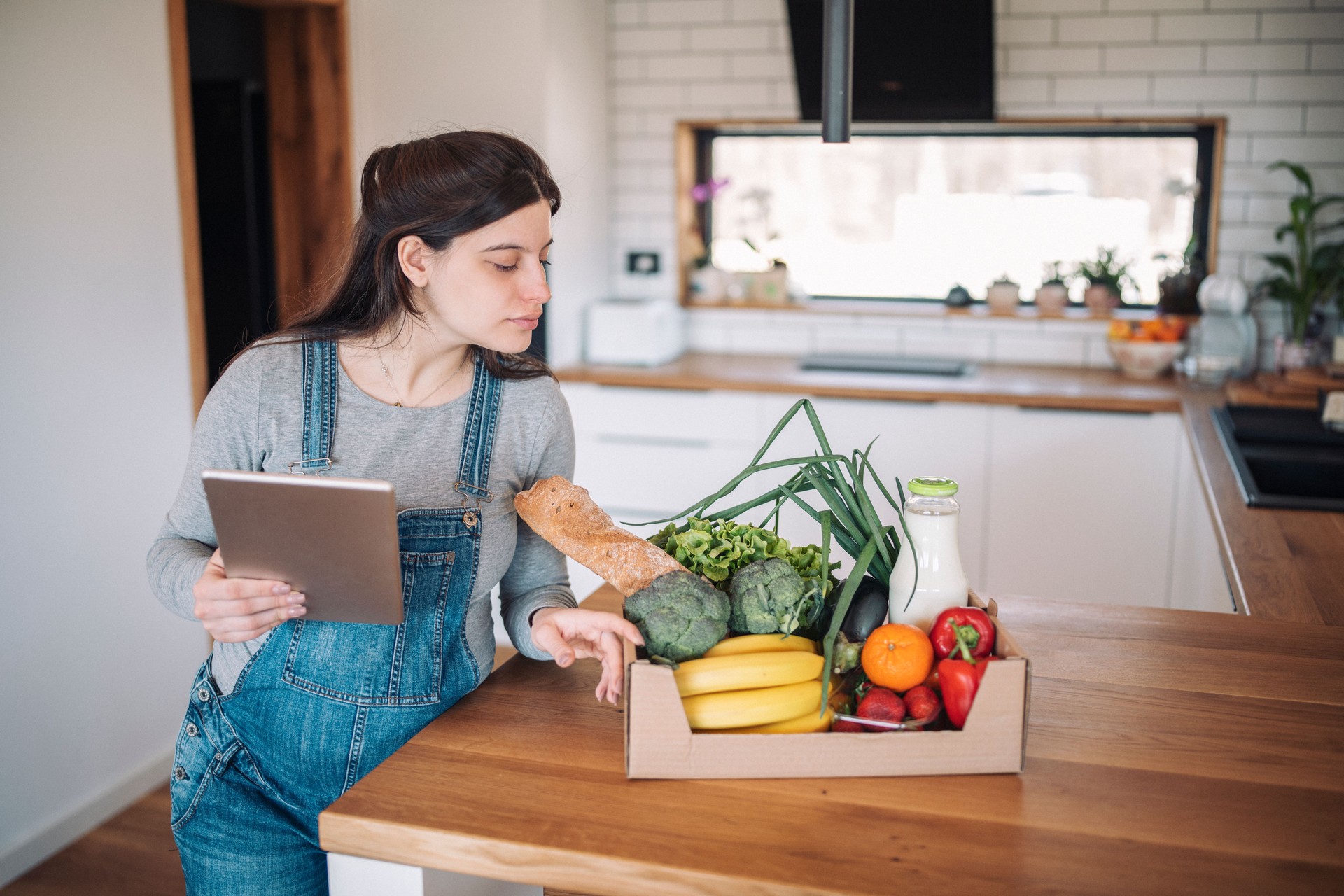 Femme vérifiant les produits du service de charcuterie.